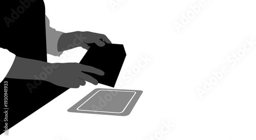 Hands placing black object into frame on white background