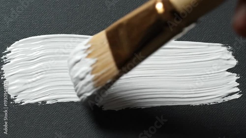 Wallpaper Mural Paintbrush applies thick white paint onto dark textured canvas Torontodigital.ca