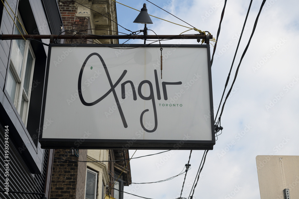 Naklejka premium wall mounted projecting sign outside ANGLR, a restaurant, located at 1054 and 1/2 Gerrard St E, Toronto