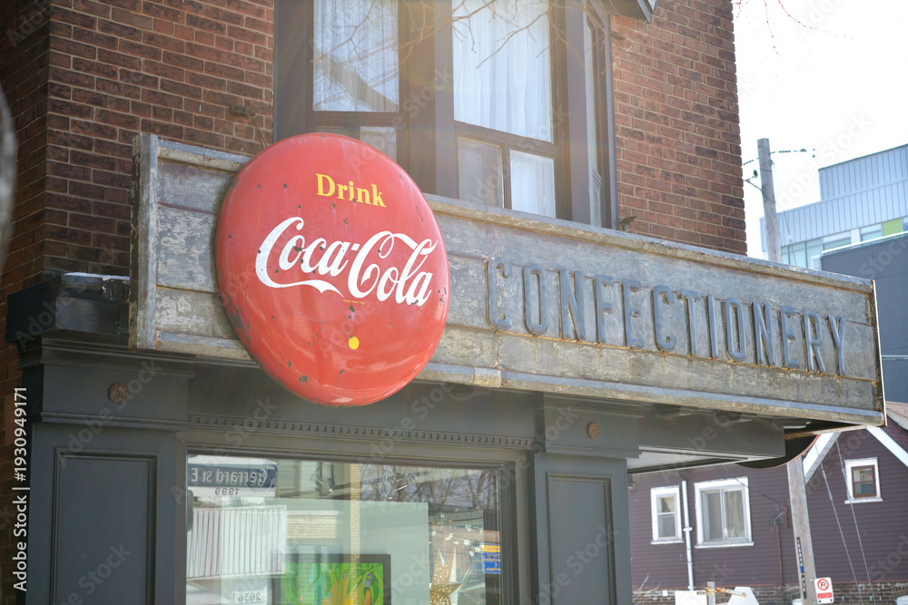 Fototapeta premium vintage remnants of Jack's Variety & Grocery, metal block letters and a Coca-Cola button sign on the exterior of 1999 Gerrard St E, Toronto