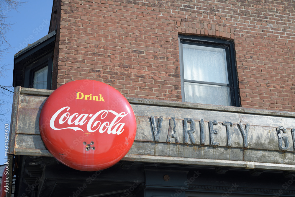 Fototapeta premium vintage remnants of Jack's Variety & Grocery, metal block letters and a Coca-Cola button sign on the exterior of 1999 Gerrard St E, Toronto