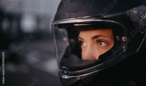 A female motorcyclist riding a motorcycle in the city in the evening