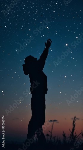 A silhouetted person looks up at a vast starry night sky in a serene natural setting.