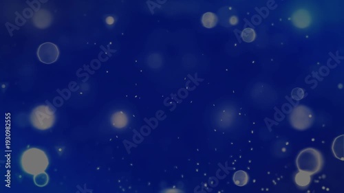Abstract deep blue background featuring soft golden bokeh lights and floating dust particles for festive holiday or elegant corporate design.