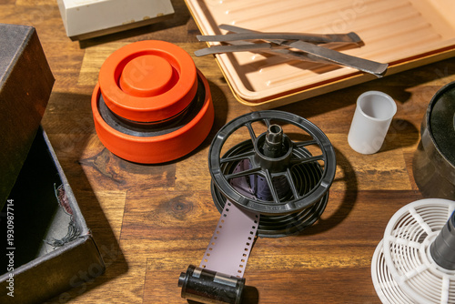 Equipment for analog photography, developing tray and film roll.