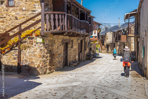 Принти на полотні Pilgrims walk through the narrow stone streets of El Acebo de San Miguel featuri