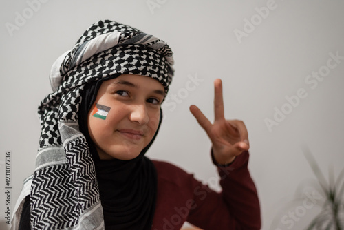 Fotografie Solidarity And Palestinian Identity Young Woman Wearing Keffiyeh And Paint Showing Support And Peace With Victory Sign Cultural Pride And Political Awareness