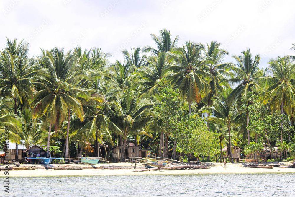 Naklejka premium Bright sunny day at the beach with golden sand, gentle waves, and clear blue sky. A peaceful seaside scene capturing the warmth of summer, fresh ocean breeze, and relaxing coastal atmosphere.