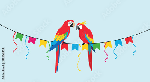 Two colorful scarlet macaws perch together on a string of festive multi-colored flags against a light blue background.
