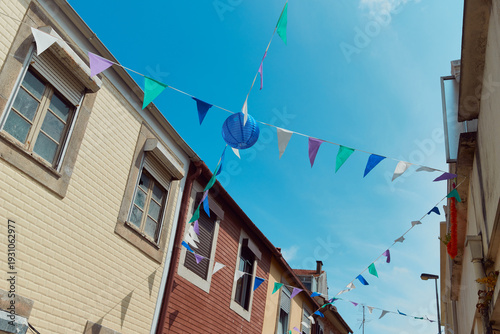 Billede på lærred Festive bunting and lanterns decorate a narrow street for summer festival in Jun