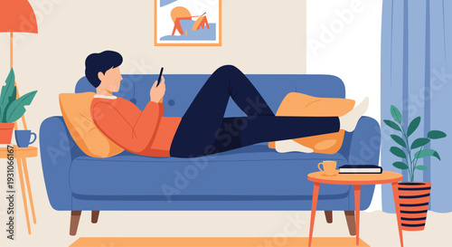 Young man relaxes on a comfortable blue sofa while looking at his smartphone in a cozy living room setting at home.