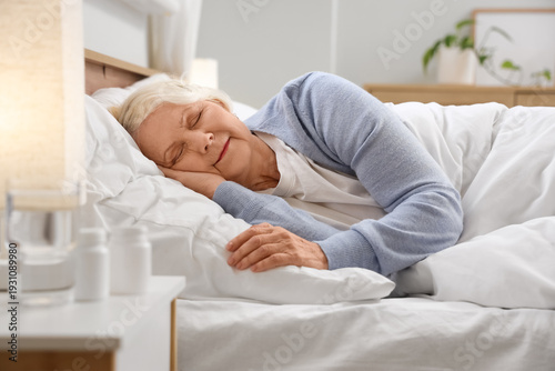 Senior woman sleeping in be...