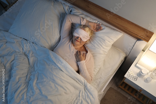 Senior woman sleeping in be...