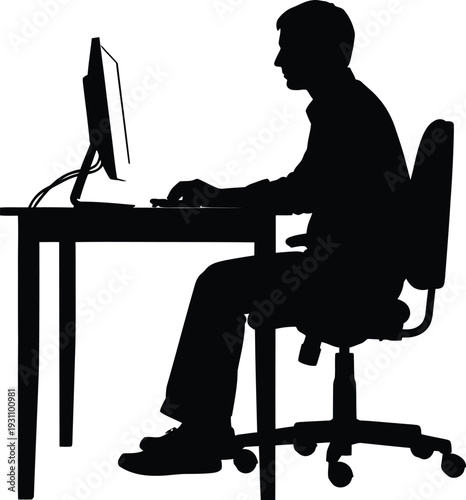 Silhouette of a focused man working diligently on a desktop computer at a simple desk while seated in an ergonomic office chair.