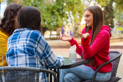 Happy teenage girls sitting...
