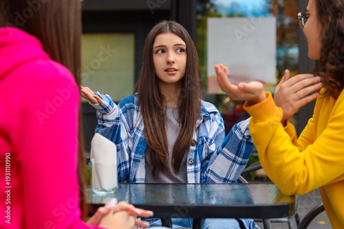 Happy teenage girls sitting...