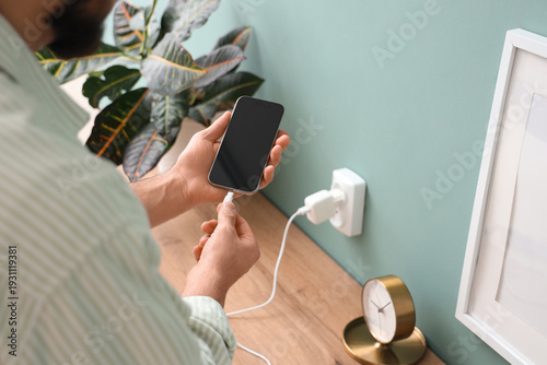 Young man connecting chargi...