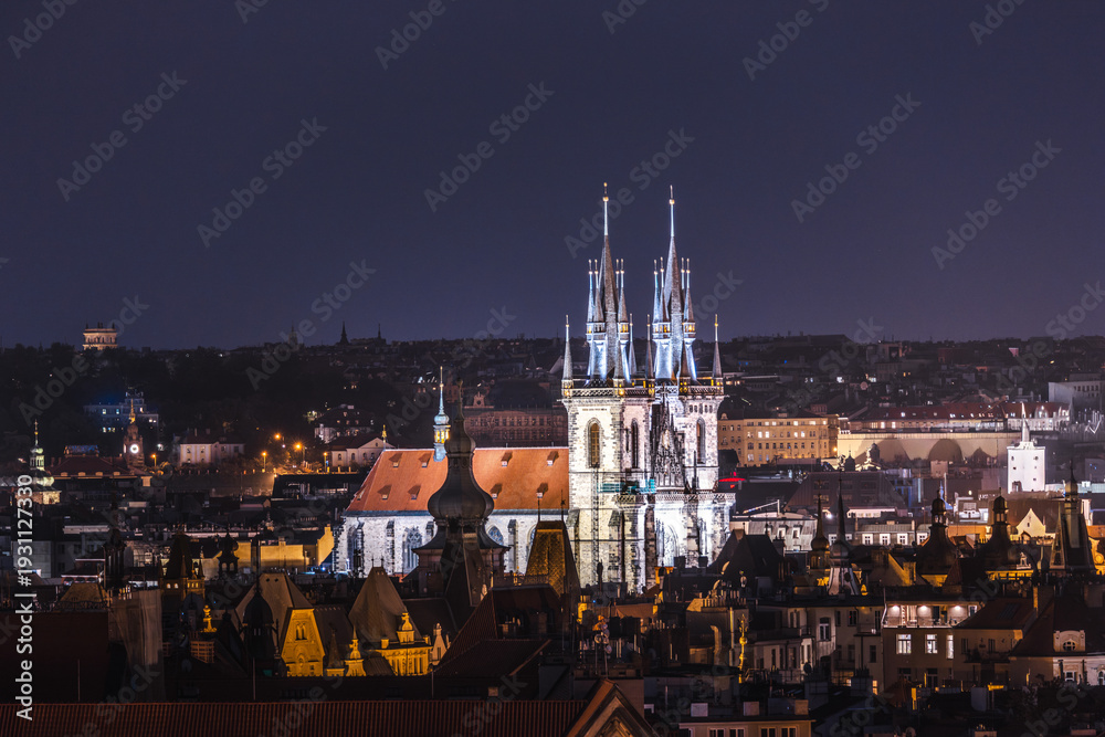 Obraz premium Evening panorama of Prague Old Town with glowing gothic towers of Church of Our Lady before Tyn above historic city roofs in Czech Republic