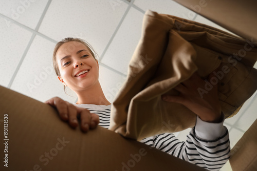 Young happy woman unpacking...