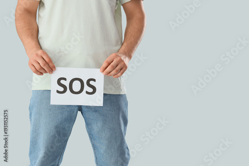 Young man holding paper wit...
