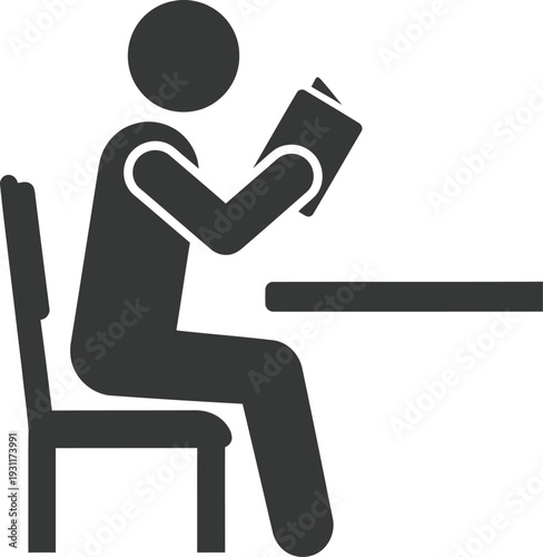 Silhouette figure seated at a table is deeply engrossed in reading a small book or document while resting on a simple dining chair.