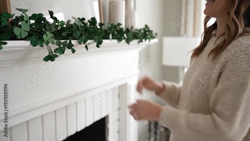 Woman decorating a white fireplace mantel.