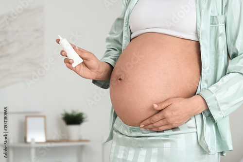 Pregnant woman applying cre...
