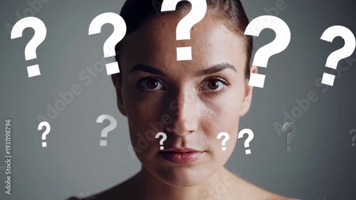 Young woman with bare shoulders is looking at camera with many question marks surrounding her head, expressing confusion, decision making, and uncertainty
