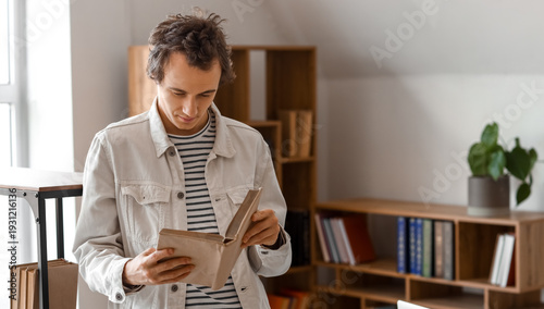 Young man reading book in l...