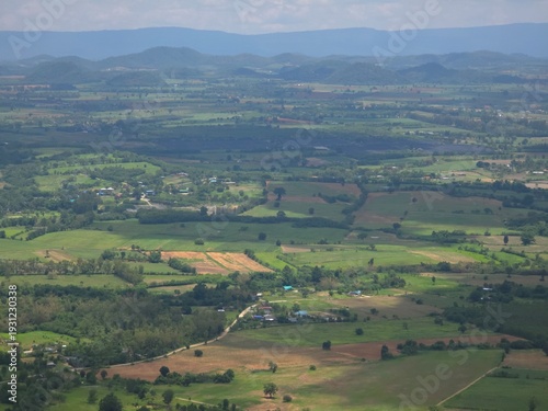 Large, open field with a few houses scattered throughout