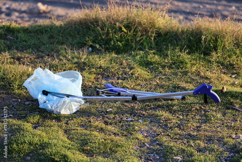 Litter pickup tool. Trash grabbing tool.Volunteers cleaning up trash in nature.