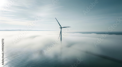 Wind turbine in the ocean surrounded by foggy weather conditions
