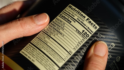 Foto Close-up of black jar of whey protein powder with nutrition facts label in woman
