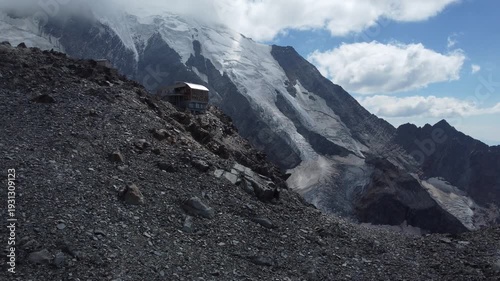 A breathtaking view of the Mont Blanc massif in the Grand Couloir area, next to the Tête Rouse Hat, with the snow-capped slopes of the Alps and the glacier in the background