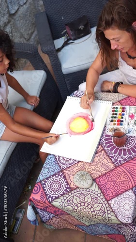 Mother and daughter painting with watercolors together