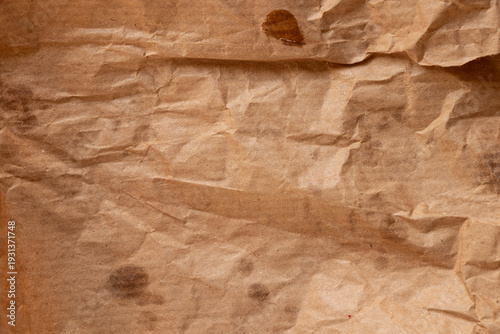 Crumpled paper bread packaging with greasy stains for the topics of food packaging, paper contamination, oil stains, and kraft paper
