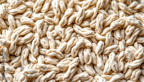 Grains, likely rice, with a close up focus on the texture and shape of individual grains. The grains are light in color, possibly indicating they are uncooked or unpolished