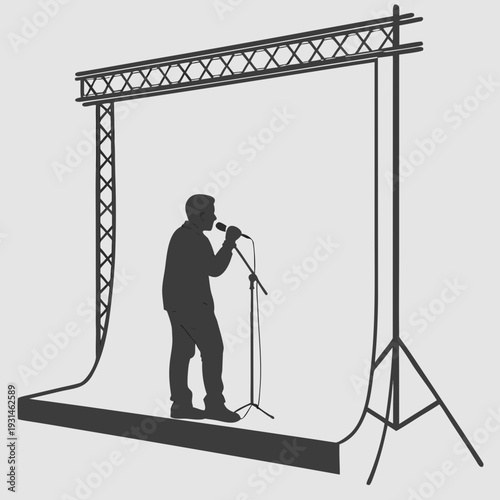 Silhouette of a male singer performing on stage with a truss structure.