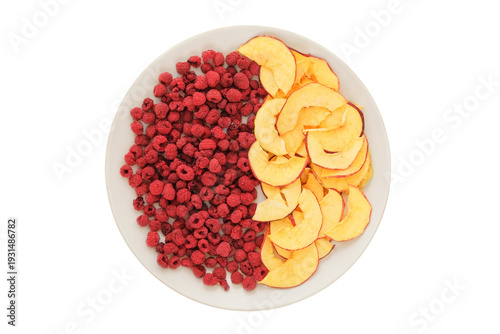 Top view. Ingredient for preparing a freeze-dried breakfast. Dried apples and raspberries in a white ceramic plate isolated on a white background.