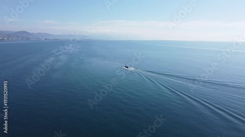 Fishing boat sailing on the sea, aerial drone view. Fisherman boat cruising on the blue sea. 