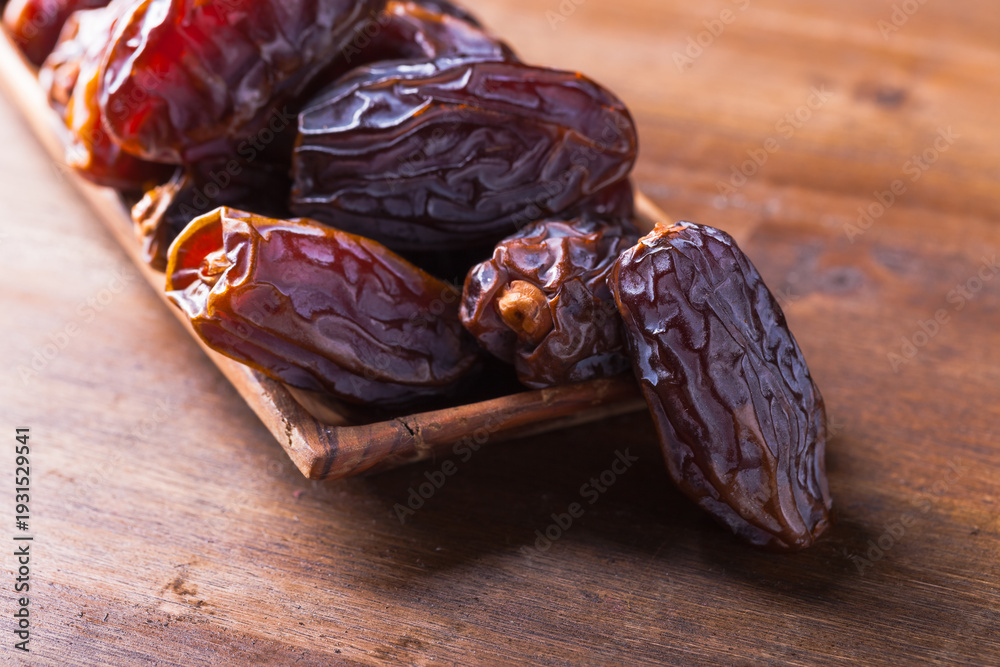 Fototapeta premium Juicy ripe dates on an old wooden table.