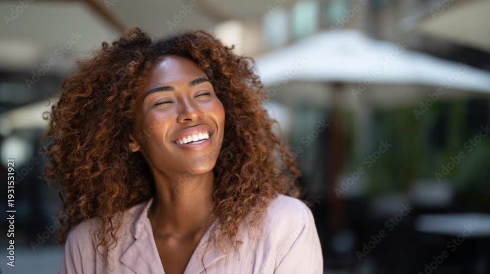 Fototapeta premium Joyful Black Woman Laughing Outdoors with Sunlight on Face