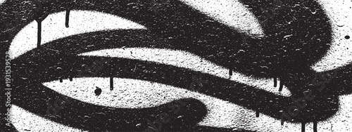 Close-up of black spray paint drips and splatters on white background, abstract texture