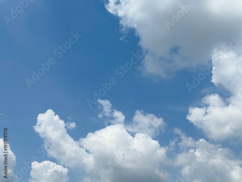 Fotografi White fluffy cumulus clouds in clear blue sky on sunny day
