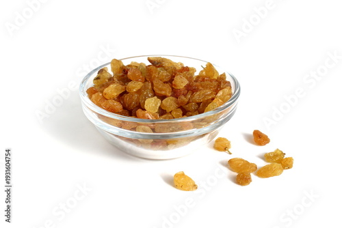 There is a glass bowl with yellow raisins on a white background.
