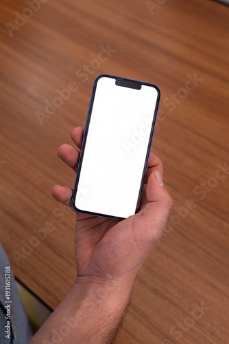 The man is holding a smartphone, from a high angle.