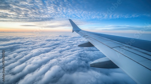 Wallpaper Mural Airplane wing over fluffy clouds at dawn. Aerial view. Photo stock Torontodigital.ca
