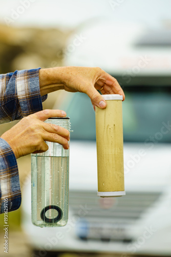 Person showing aqua filter cartridge used in caravan.