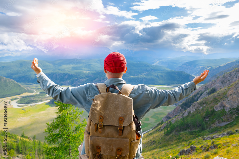 Fototapeta premium Happy hipster tourist with backpack embracing stunning Altai mountains landscape, Russia