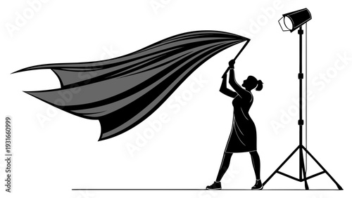 Woman holding a flowing cape in a studio setting with a spotlight.